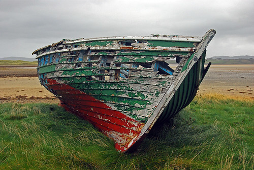 Shipwrecked boat on the windswept sandy Traemore Beach in Ireland