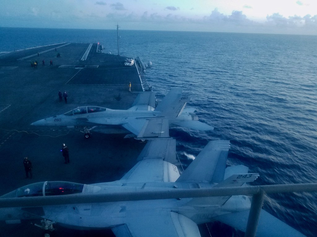 Jets on the flight deck at dusk viewed from the Flag Bridge. Photo by howderfamily.com; (CC BY-NC-SA 2.0)
