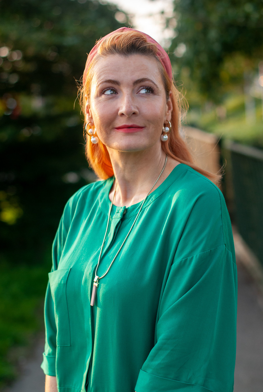 "Wearing a Colour I Don't Normally Wear: Emerald Green" by Over 40 Blogger Not Dressed As Lamb (outfit of emerald green shift dress over black flare trousers \ black wedge espadrilles \ pink headband \ green on pink tote bag)