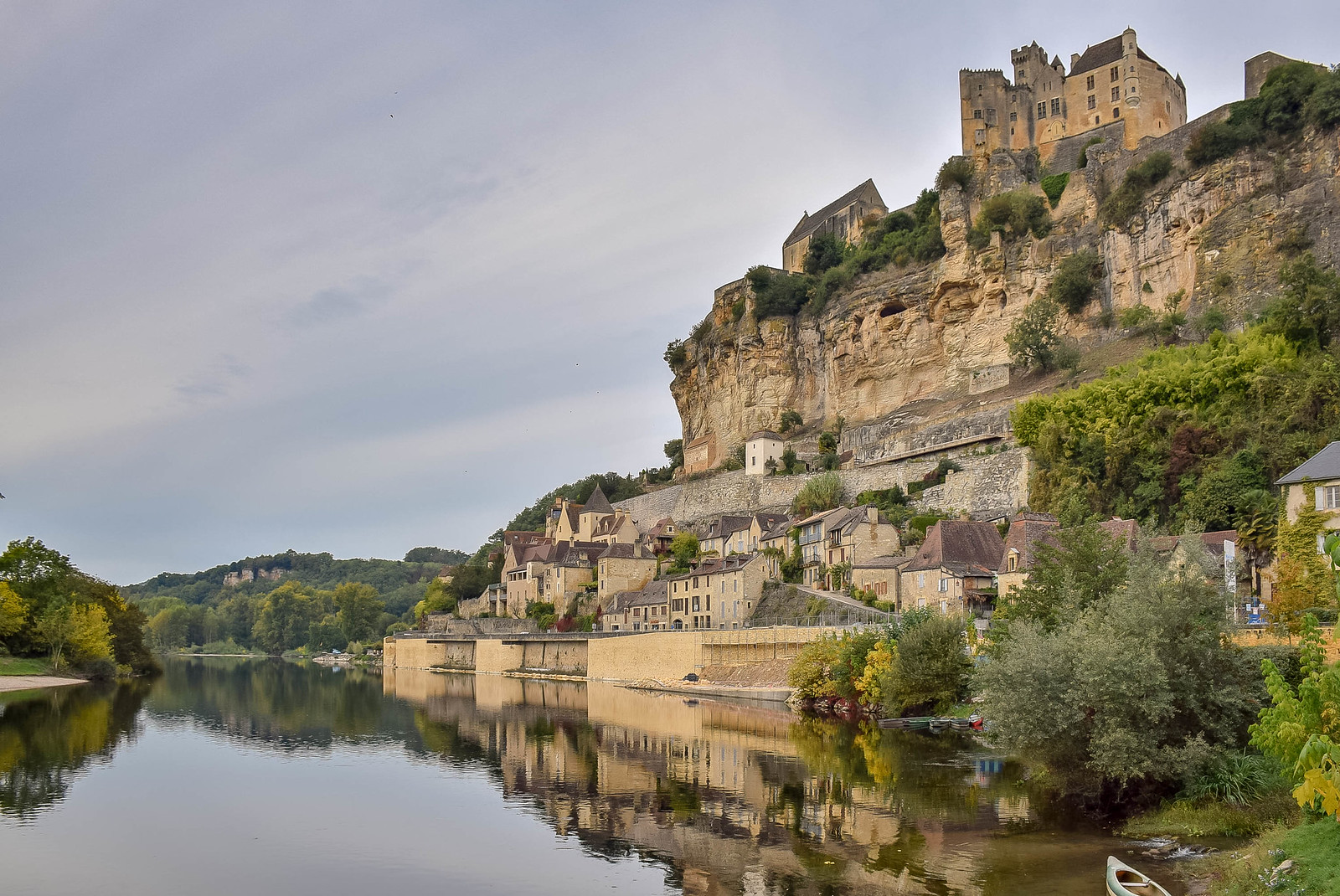 Medieval town of Rocque Gageac and its castle reflected on the river in France - - one of the prettiest towns in the Dordogne.