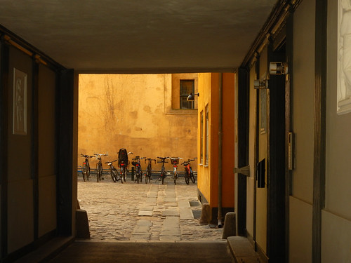 Bikes parked neatly up against a yellow wall in Copenhagen, Denmark
