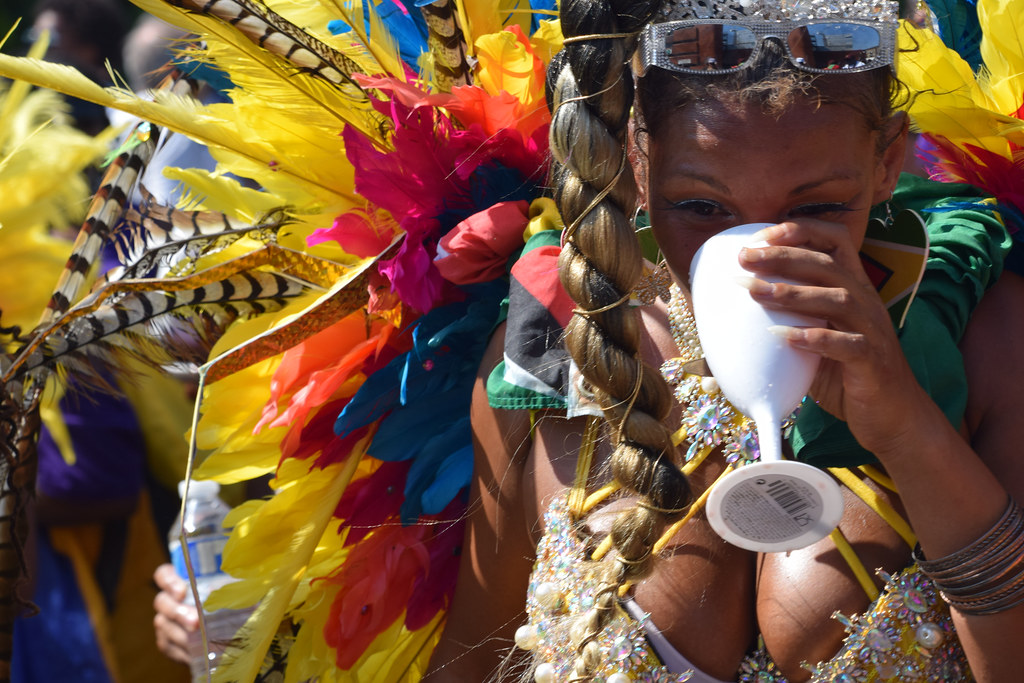 DSC_5232 Notting Hill Caribbean Carnival London Mas Players Parade Participant Performers Exotic Colourful Gold Showgirl Costume Ostrich Feather Headdress August 26 2019 Stunning Girl Décolleté Low Neckline Beautiful Breasts Cleavage