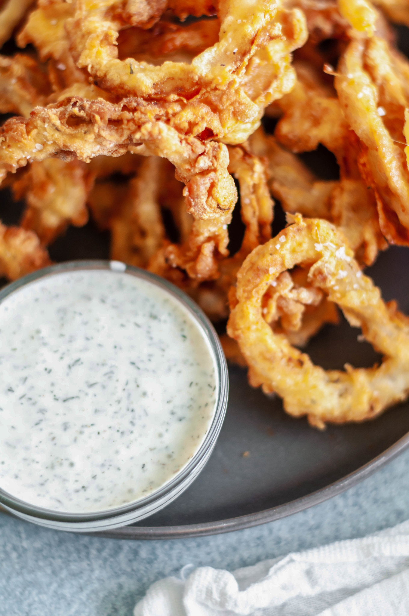 These Crispy Onion Rings with Buttermilk Dill Dressing will be the hit of the party. Perfect for appetizers, game day or to go with your burgers.