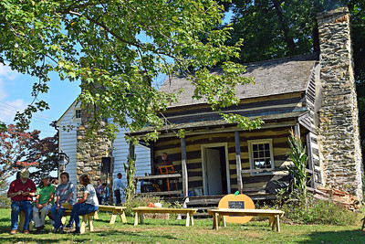 Visitor relax outside the Log Cabin, listening to live music.