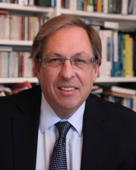 Photograph of Professor Duncan Angwin in front of a bookshelf.