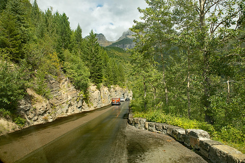 montana flatheadcounty whitebus 1936 goingtothesunhighway glaciernationalpark historic redbuses symbol touringcoaches fordmotorcompany renovated bus visitors clouds sky gardenwall rain nationallandmark nationalregisterofhistoricplaces nationalhistoriccivilengineeringlandmark npsrusticstyle