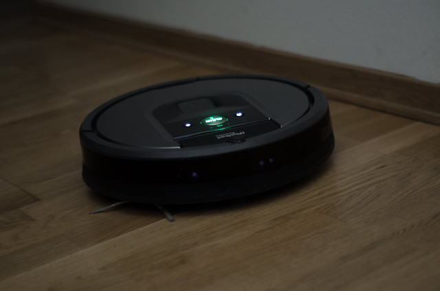 Roomba cleaning a wooden floor at night