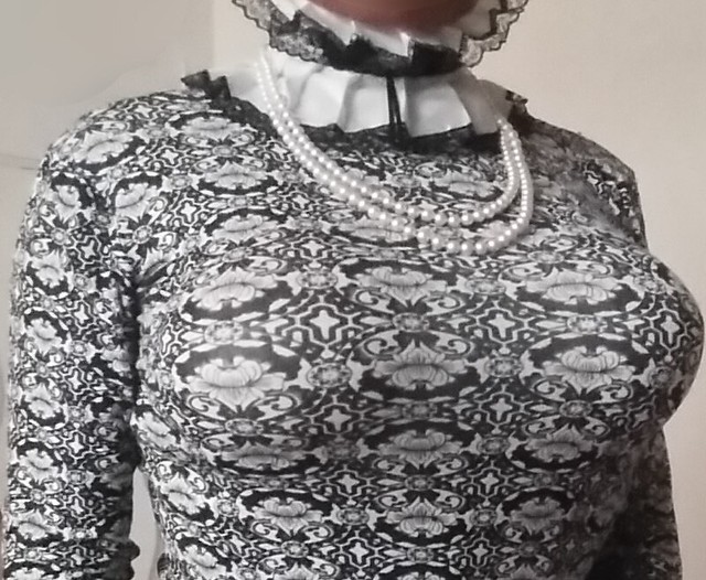 Big boobs with corset, suspender and stockings with a tight posture collar underneath the frilly collar