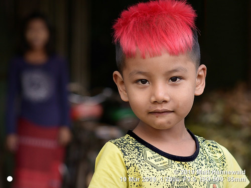 matthahnewaldphotography facingtheworld qualityphoto head face eyes childreneyes expression dyed pink hairstyle consensual parentalconsent conceptual diversity humanity living lifestyle beauty upbringing childhood prosperity fashion style impact local cultural motherandchild son pakokku burma myanmar asia asian burmese person two child little boy woman nikond610 nikkorafs85mmf18g 85mm 4x3ratio resized 1200x900pixels horizontal street portrait doubleportrait halflength closeup fullfaceview outdoor colour posing cute incredible depthoffield background undercut haircut trendy dyedhair clarity lookingatcamera
