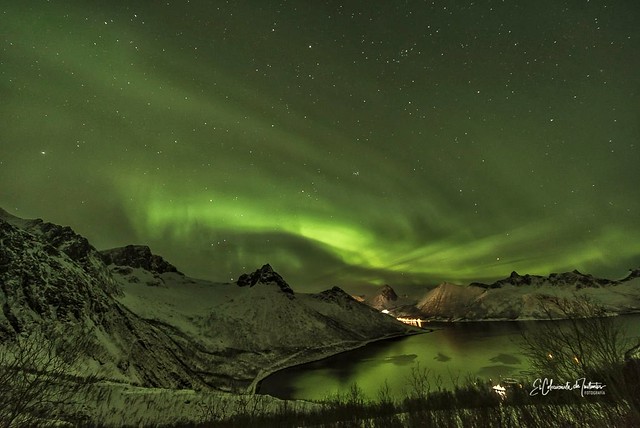 Aurora Boreal y reflejos verdes sobre Fjordgard Isla de Senja