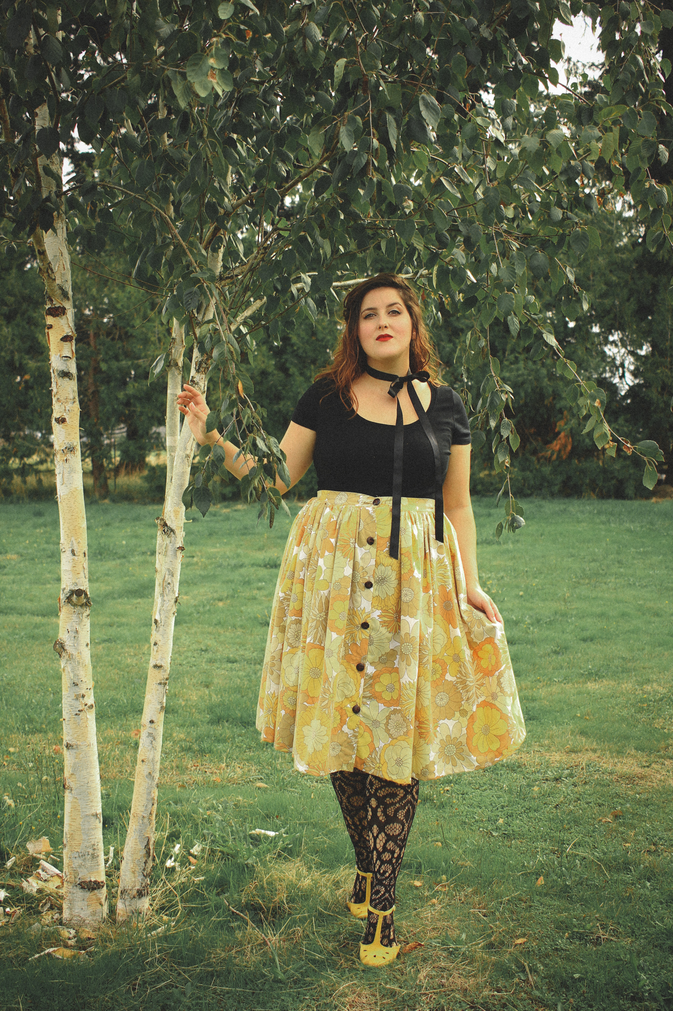 woman wearing a black top and a floral skirt in a vintage style