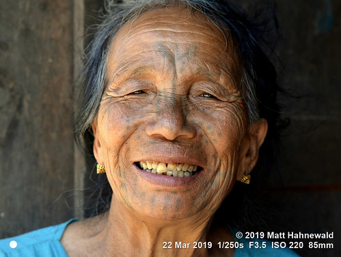 face tattoo nose eyes head character traditional tribal tribe chin facialtattoo qualityphoto facingtheworld matthahnewaldphotography travel humanity expression diversity exotic local tradition conceptual ethnic wrinkles hilltribe consensual livedinface old woman female rural asian person one women asia village burma myanmar cultural mindat chinstate street portrait colour smiling closeup outdoor 85mm posing headshot authentic nikkorafs85mmf18g nikond610 fun teeth impact muun cheek clarity lookingatcamera seveneighthsview