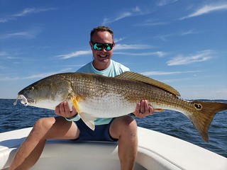 Photo of man holding up a big red drum