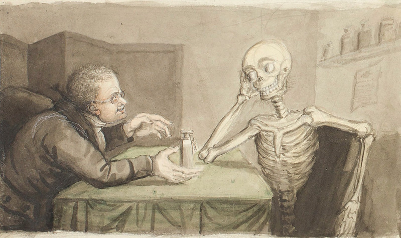 Man sitting at a table with a skeleton