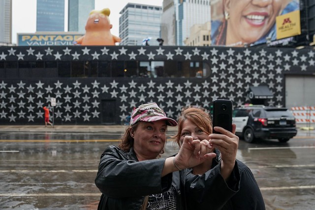 Before the rally, Trump supporters take a selfie with the Baby Trump balloon outside First Avenue