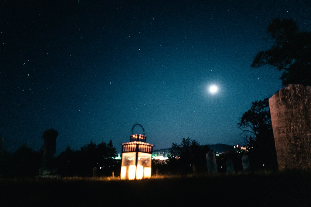 A candelit lantern below the moon on a Haunted Lunenburg Walking Tour