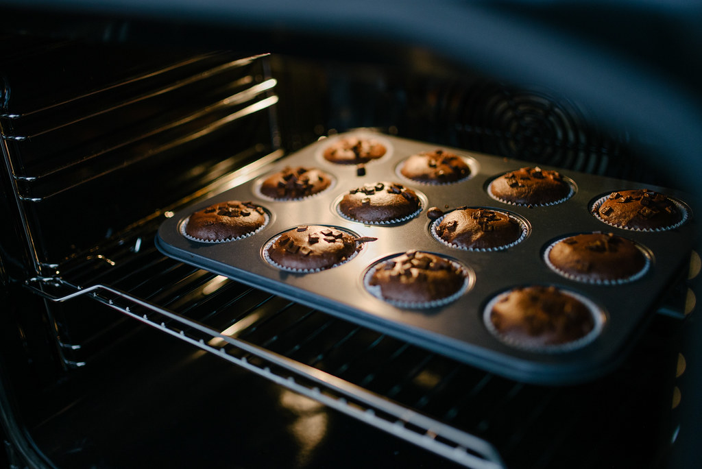 Homemade muffins with chocolate crumbs in a baking tray in an oven