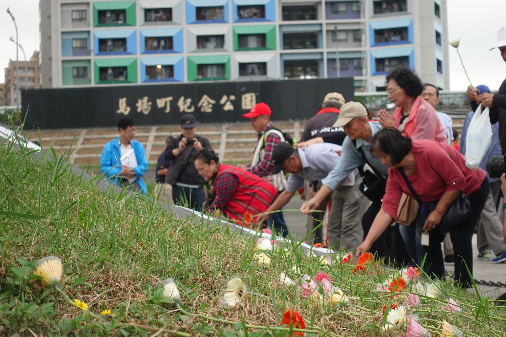 受難者及其家屬遺族、聲援民眾在馬場町的土丘上獻花。（攝影：張智琦）