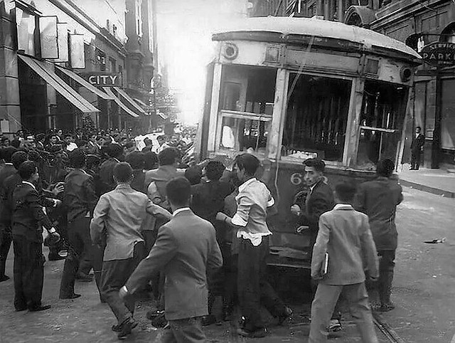 Manifestantes vuelcan un tranvía en calle Agustinas en protesta contra políticas económicas del presidente Carlos Ibáñez del Campo. Santiago de Chile, abril de 1957