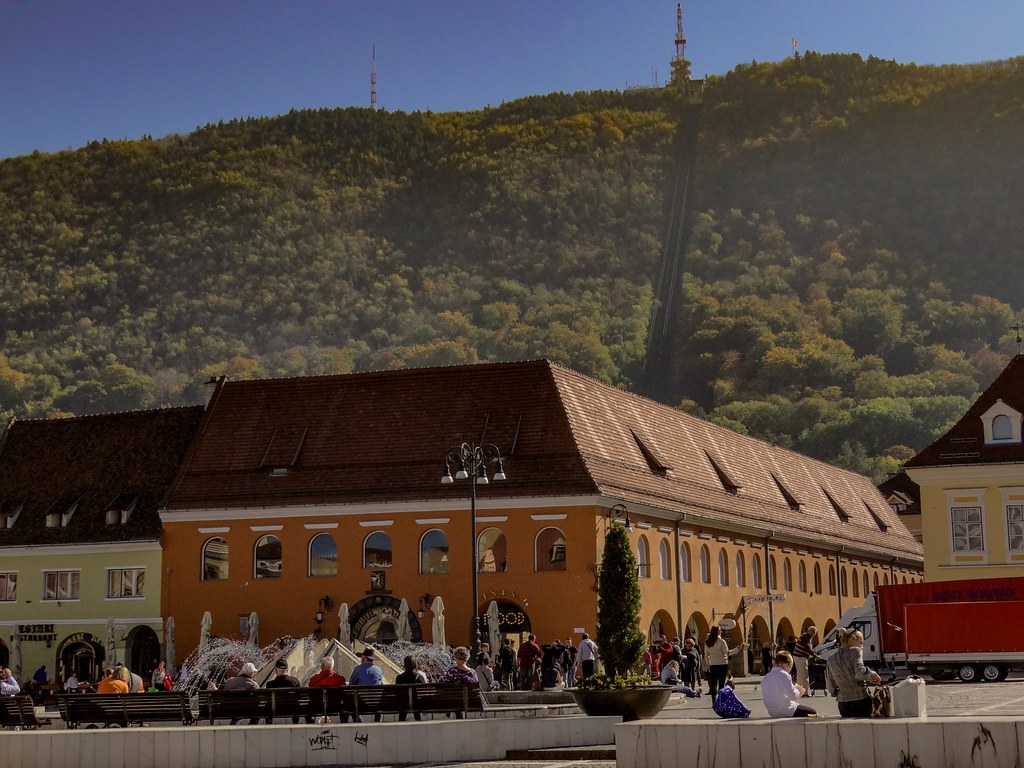 Sunny afternoon in the city center of Brasov, Romania with the Carpathian mountain background.