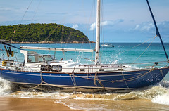 Disaster at sea. The wreck of a sailing yacht. Yacht was dropped from the anchor and thrown to the beach. Waves break the hull and fill it with water. Nai Harn Beach, Phuket, Thailand 25 October 2019