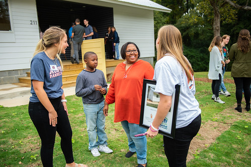 Auburn University students stand with the Dumas family in front of the Habitat for Humanity house. 