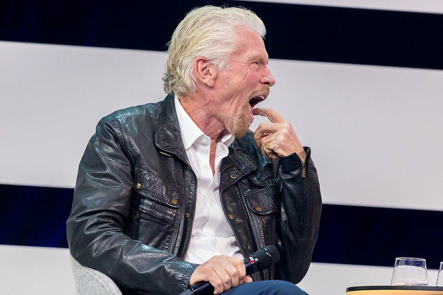 Richard Branson yawning on stage of Digital X