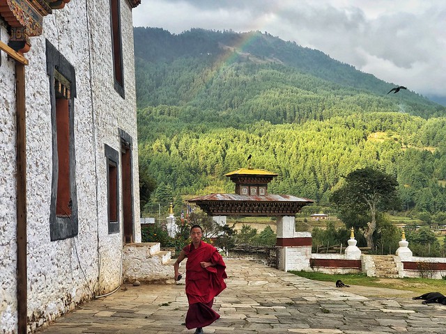 Escena con arcoiris y monje budista en Bumthang (Bután)