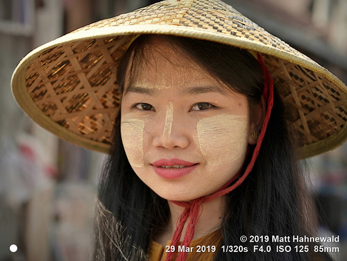 matthahnewaldphotography facingtheworld qualityphoto head face oriental eyes nose mouth lips expression longhair hat conical sunhat ricehat paddyhat consensual travel tourism lifestyle love grace beauty style ethnic local traditional cultural kalaw shanstate myanmar burma burmese asia asian person one female young woman women nikond610 nikkorafs85mmf18g 85mm street portrait closeup headshot sidewaysglance outdoor colour posing feminine beautiful sensual pretty lovely soulful thanaka happyplanet clarity bangs cheek straw lookingatcamera closedmouthsmile seveneighthsview
