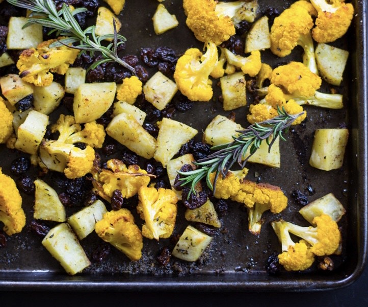 An easy and impressive side dish. Roasted cauliflower seasoned with fragrant spices of cumin and curry along with fresh rosemary and sweet raisins.