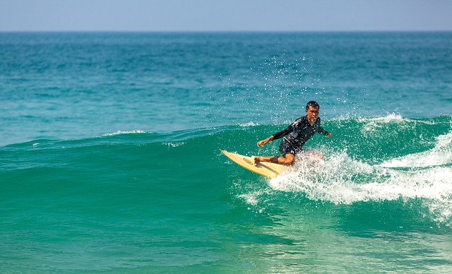 Surfing in the cool waves at Nai Harn Beach, Phuket, Thailand.