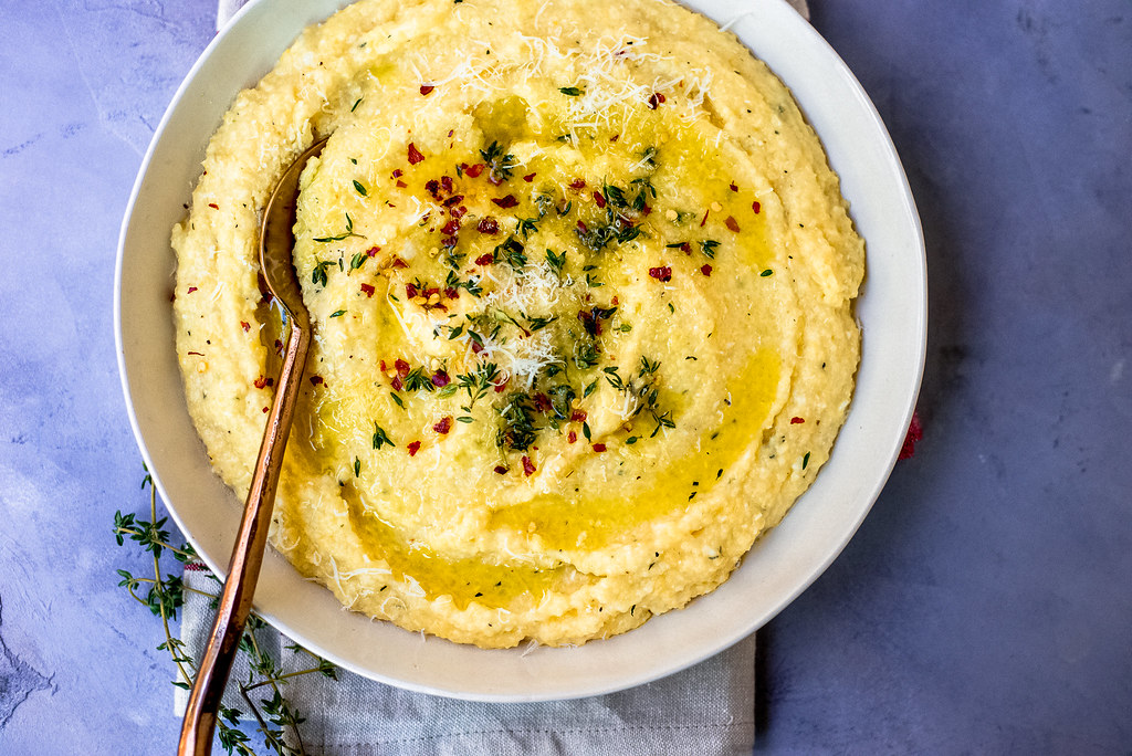 A simple and impressive side dish. Creamy polenta is tossed with fresh thyme and grated Parmesan cheese making it perfectly savory.
