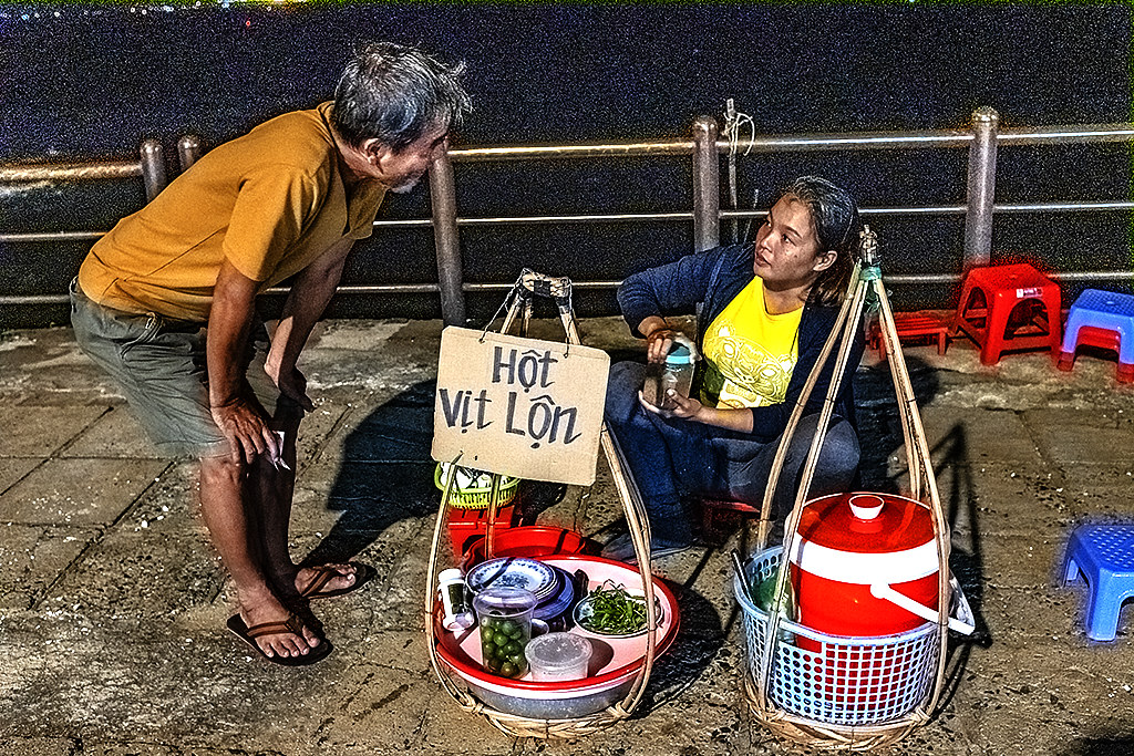 Nguyen Quoc Chanh talking to a balut vendor at Mulberry Beach--Vung Tau