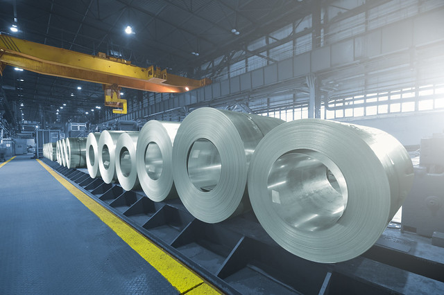 Roll of steel sheet in a plant, picjked up by crane