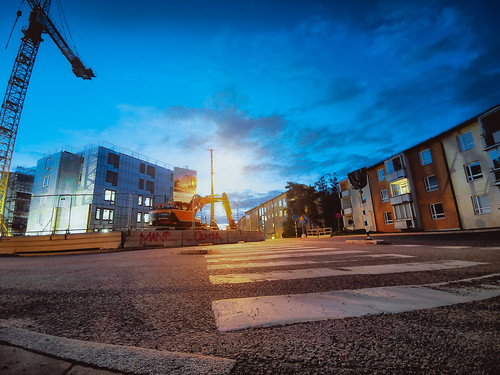 road pedestriancrossing sidewalk sunrise sunrisebehindexcavator nopeople dawn early summermorning constructionsite crane newbuilding buildings skyline bluesky clouds lowperspective lowpov asphalt tarmac home shadows