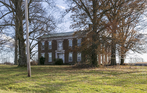 house dwelling residence farmhouse vacant abandoned greekrevival brick historic centralpassage fivebay twostory ihouse trabeateddoorway sidelights transom trees bushes shrubbery nicholascounty kentucky millersburg entablature