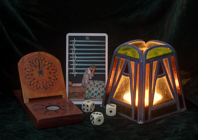Still life with a compass, a tarot card and dice