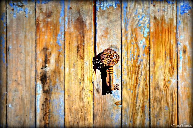 Mystérieuse et ancienne clé sur une porte à la peinture bleue écaillée