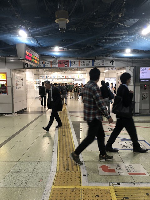 Crowds of people navigating their way through Shinjuku Station