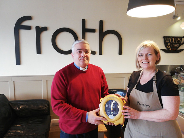 The Rev James Boyd presents a defibrillator to Karen Campbell, proprietor of Froth coffee shop, on behalf of St Columba's, Derryvolgie.