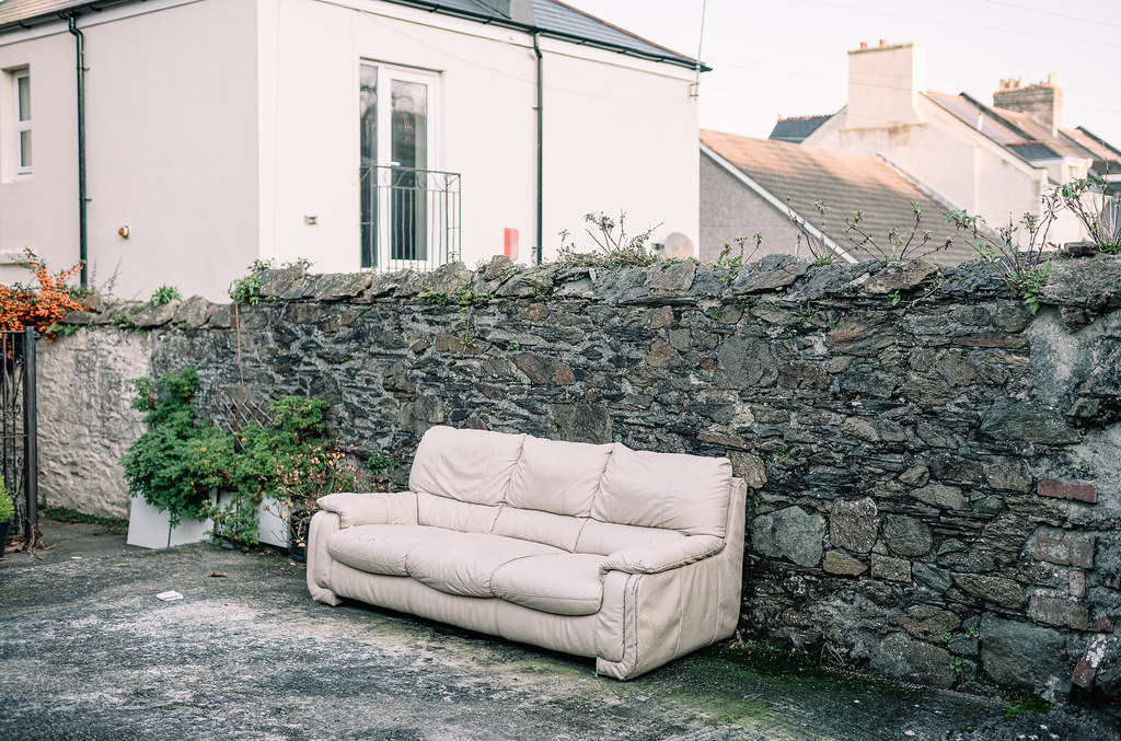Outdoor Living - a couch sitting on the ground in front of a stone wall