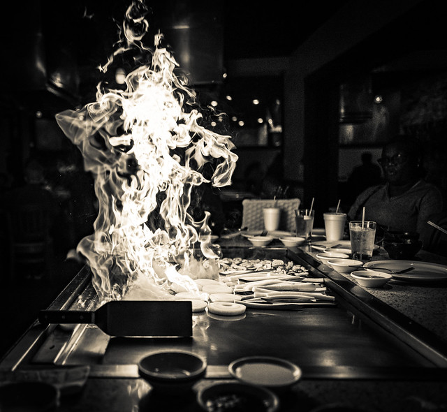 A hibachi chef cooking at a teppanyaki grill