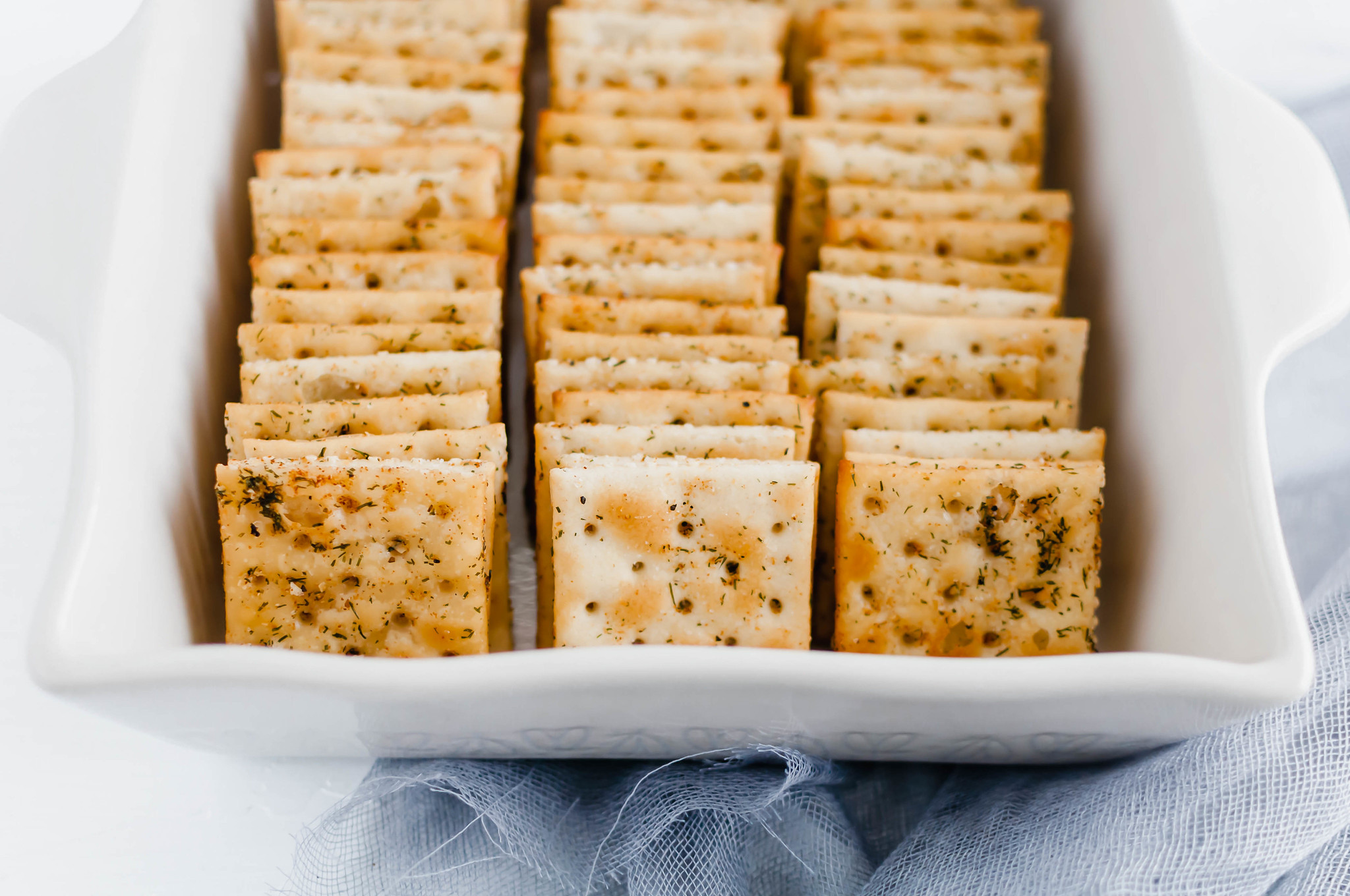 Seasoned Saltine Crackers are wonderful as a snack or a dipper for all the soups this winter. Tossed in oil, spices and herbs then baked to crispy perfection.