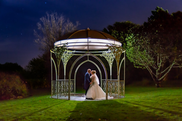 Wedding shot at the Moorland Garden Hotel on Dartmoor.  Rebecca and Carl - backlit in the dark under the Rose Arbour
