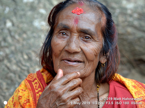 facingtheworld character head face forehead ricetilaka tika thirdeye eyes mirror reflection temple expression prayershawl hand respect dignity diversity humanity living travel society poverty local religious traditional cultural hindu hinduism beggar manakamana gorkhadistrict nepal asia asian nepali human person one female old woman primelens nikkorafs85mmf18g 85mm street portrait closeup outdoor colour posing authentic poor clarity catchlights lookingatcamera seveneighthsview headshot nikond610 matthahnewald