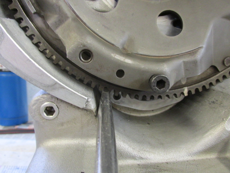 Use Large Flat Blade Screwdriver Between Flywheel Teeth to Stop Flywheel From Turning