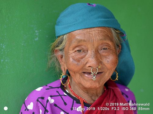 matthahnewaldphotography facingtheworld character head face eyes nose nosepiercing septumpiercing nosejewelry nosering nosestud gemstonejewelry earring livedinface wrinkles expression respect dignity humanity travel lifestyle grace beauty exotic ethnic tribal indigenous native local rural traditional cultural villager arkhetbazaar manaslutrek nepal asia asian nepali magar human person one female elderly old woman detail primelens nikkorafs85mmf18g 85mm street portrait closeup indoor naturallight colour posingcamera clarity happyplanet lookingatcamera seveneighthsview headshot nikond610