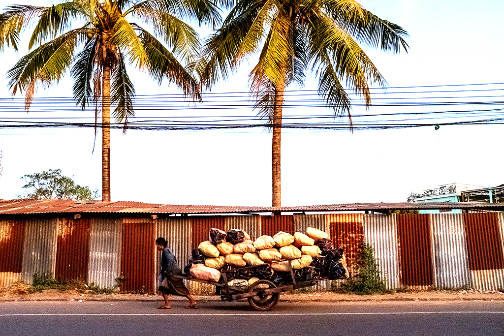 Woman pulling cart with heavy load-Savannakhet