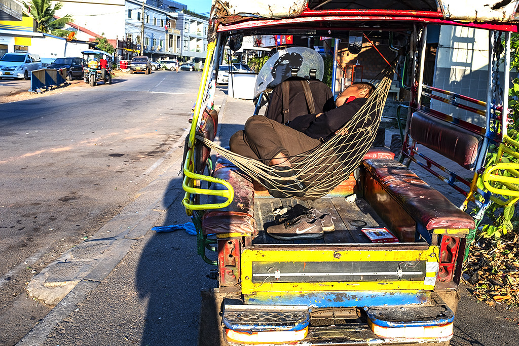 Man sleeping on hammock at the back of a tuk tuk--Vientiane