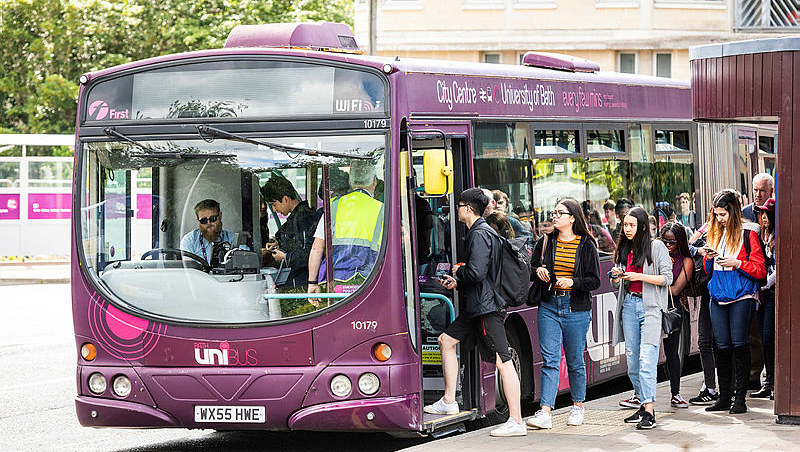Students getting on a bus on campus